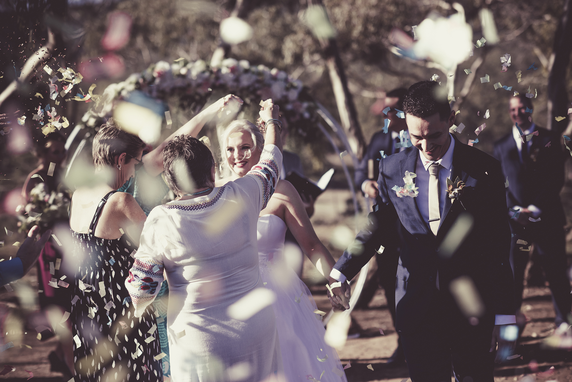wedding couple walking down the aisle being showered by confetti